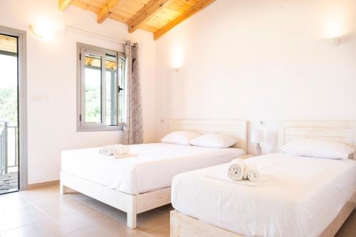 two beds in a room with white walls at Janakis Garden Livadi Beach in (( Spile ))