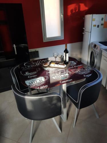 stół jadalny z krzesłami i butelkę wina w obiekcie Cabaña Loft La Ribera w mieście Maipú