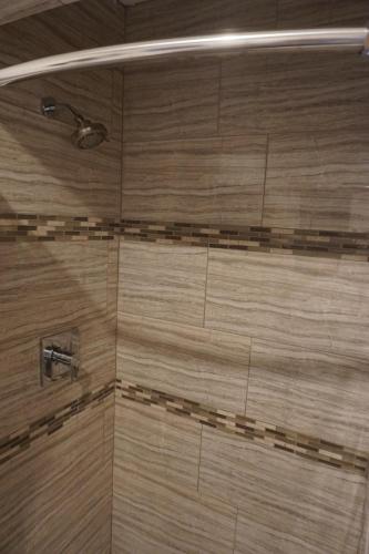 bagno con doccia e piastrelle marroni di Las Palmas Hotel a Los Angeles