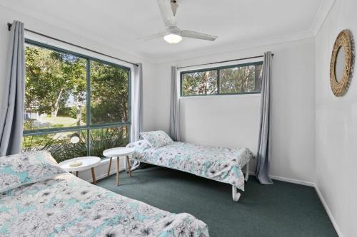 um quarto com 2 camas e uma janela em Billabong em Point Lookout