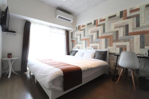 a bedroom with a large bed and a window at Forest Inn Fukuoka -previously Pure Tenjin- in Fukuoka