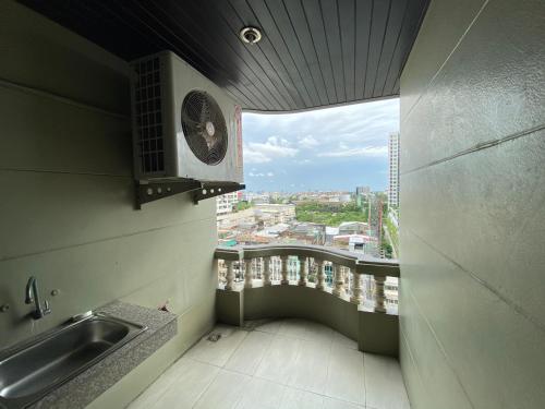 una cucina con lavandino e un balcone con finestra di Boss Mansion a Bangkok
