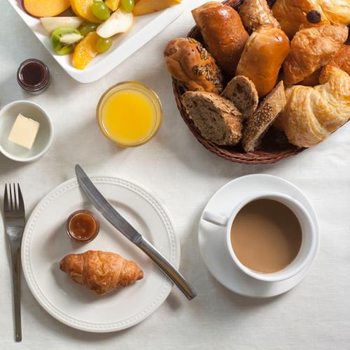 a table with a plate of bread and a cup of coffee at Family Ties Vacation Home - Greenham House in Twillingate