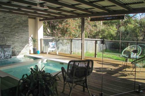 a deck with a chair and a swimming pool at Arthouse Six in Margaret River Town
