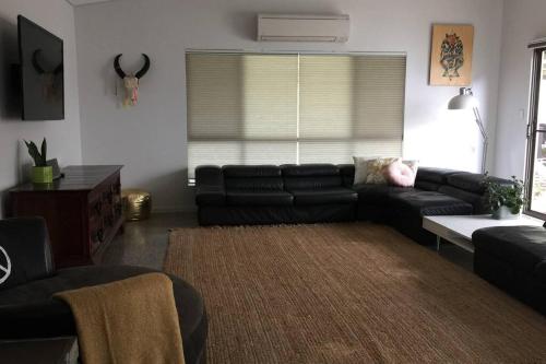 a living room with a black couch and a rug at Arthouse Six in Margaret River Town
