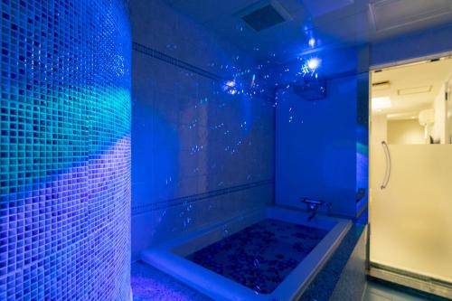 une salle de bains bleue pourvue d'une baignoire avec des lumières bleues. dans l'établissement Hotel Luna Ibaraki(Adult Only), à Ibaraki