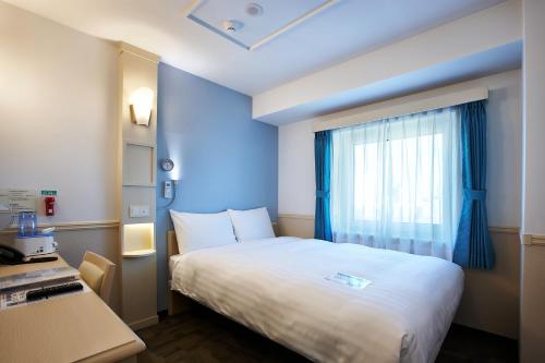 a hotel room with a bed and a window at Toyoko Inn Seoul Yeongdeungpo in Seoul