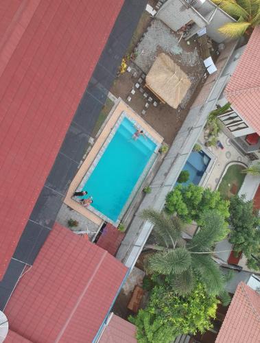 an overhead view of a swimming pool with red roofs at Jeri Home Stay in Kuta Lombok
