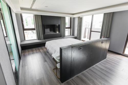 um quarto com uma cama e uma televisão de ecrã plano em Q21 Hotel em Kaohsiung