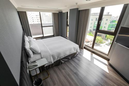 a bedroom with a bed and a large window at Q21 Hotel in Kaohsiung