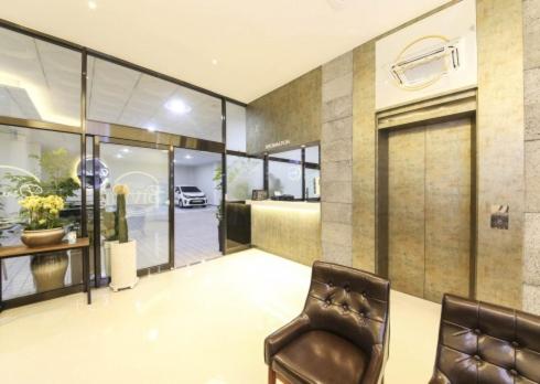 a living room with two chairs and a door to a garage at Gwangju Divine Hotel in Gwangju