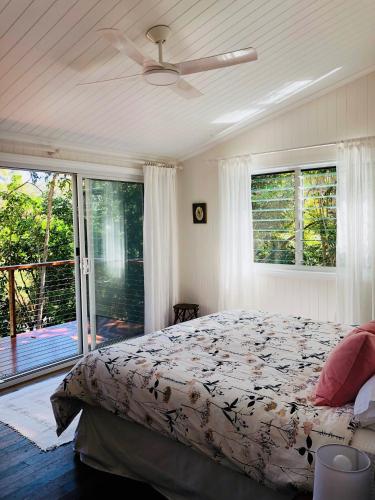 a bedroom with a bed and a ceiling fan at Billa Bush Cottage in Point Lookout