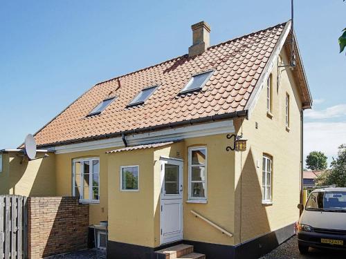 グドイェムにある2 person holiday home in Gudhjemの縞屋根の黄色い家