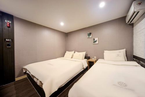 two beds in a small room with at Welkin Hotel in Busan