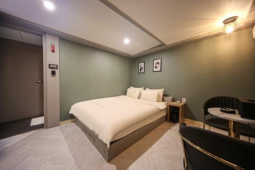 a hotel room with a bed and a chair at Welkin Hotel in Busan