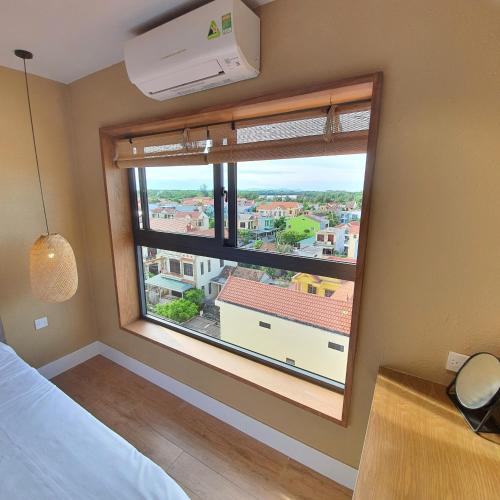 a bedroom with a large window with a view at Cagina Boutique Hostel in Dong Hoi