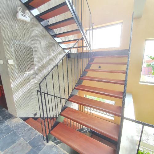 a metal staircase with wooden steps in a house at Cagina Boutique Hostel in Dong Hoi