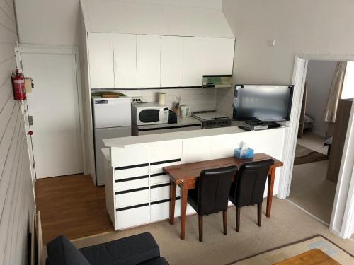 a kitchen with a table and chairs and a kitchen with a microwave at Shamrock Apartment 4 in Mount Hotham