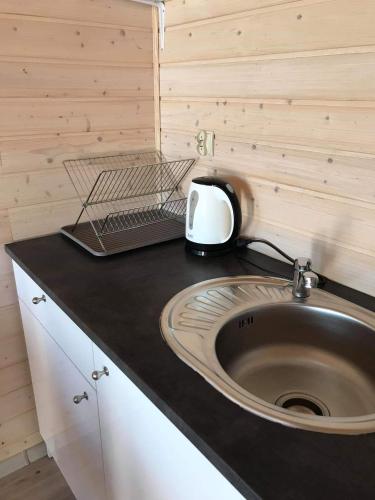 a kitchen with a sink and a toaster on a counter at Uroczy Zakątek Domki w Sarbinowie in Sarbinowo