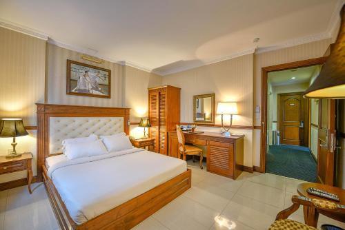 a hotel room with a bed and a desk and a desk at Boutique Garden Hotel in Ho Chi Minh City