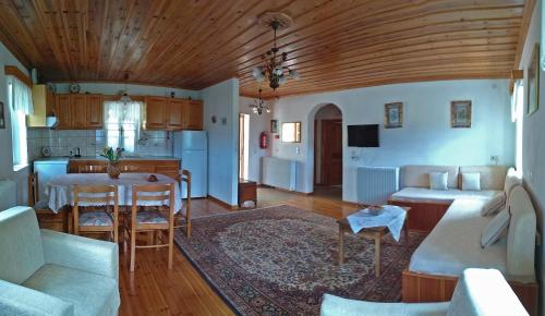 uma sala de estar e cozinha com mesa e cadeiras em Guesthouse Iro em Papingo