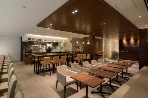 um restaurante com mesas e cadeiras e um bar em First Cabin Akasaka em Tóquio