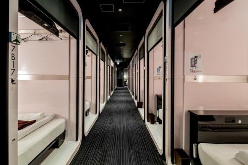 un couloir de train avec des lits à l'intérieur dans l'établissement First Cabin Akasaka, à Tokyo