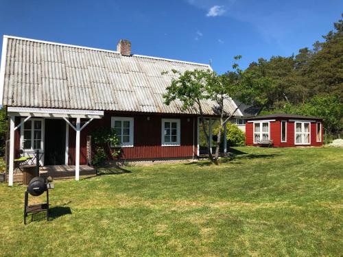 a red and black house with a yard at Sarapuu puhkemaja in Hullo