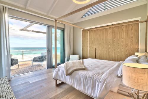 a bedroom with a bed and a view of the ocean at Rock Villa in Cape Town