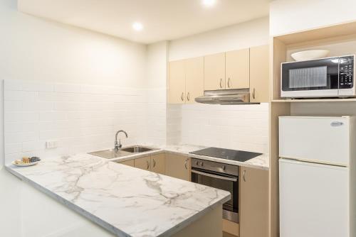 a kitchen with marble counter tops and a microwave at The Brighton Apartments in Toronto