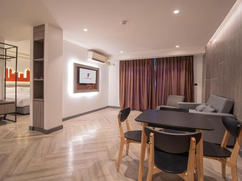 a living room with a table and chairs and a couch at Fortune D Hotel Phitsanulok in Phitsanulok