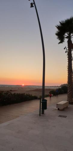 un lampione e una palma al tramonto di Casa Nonna Graziella a Gela