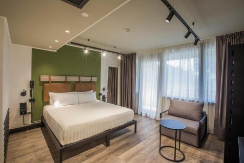 a bedroom with a bed and a chair at Mercure Roma Cinecittà in Rome