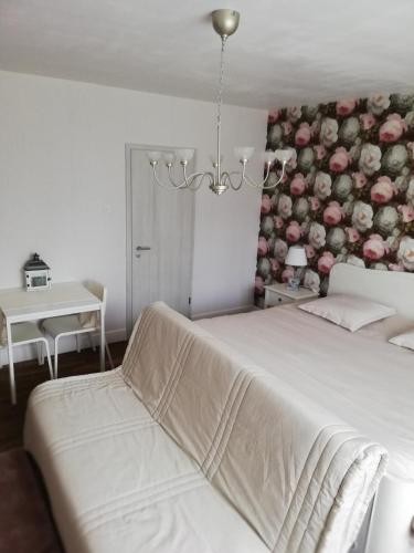 - une chambre avec un lit et un mur orné de fleurs dans l'établissement Chambres d'hôtes Sandrine Louis, à Phalsbourg