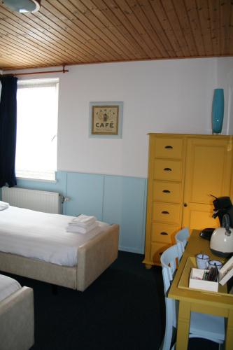 a bedroom with a bed and a desk with a table at Hotel Verhoeven in Uden
