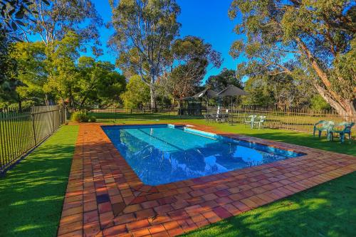 a swimming pool in a yard next to a park at Mountain View Motor Inn & Holiday Lodges in Halls Gap