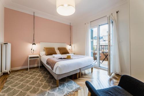 1 dormitorio con cama y ventana grande en ZABALETA SUITE by Sweet Home San Sebastian, en San Sebastián