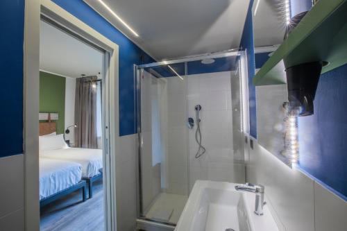 bagno con doccia, lavandino e specchio di MOVIE MOVIE HOTEL a Roma