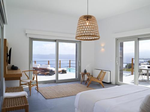 a bedroom with a bed and a view of the ocean at Melidonia Suites in Akrotiri