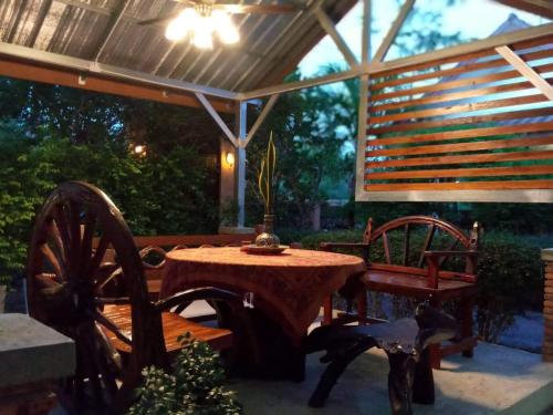 a patio with a table and chairs under a roof at Baan B&B Sukhothai in Sukhothai