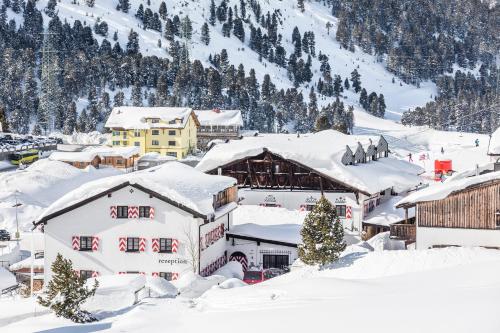 a town covered in snow with a mountain in the background at Hotel Jagdschloss Resort in Kühtai