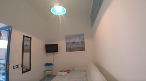 Zimmer mit einem Bett und einer Lampe an der Wand in der Unterkunft Lipari By The Beach in Lipari