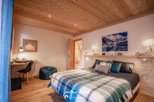 une chambre avec un lit et un bureau dans une pièce dans l'établissement Chalet Ecrin, à Saint-Chaffrey