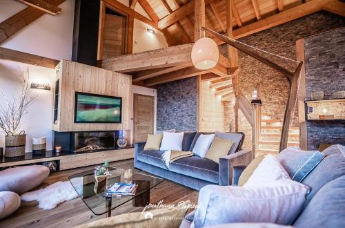 un salon avec un canapé et une cheminée dans l'établissement Chalet Ecrin, à Saint-Chaffrey