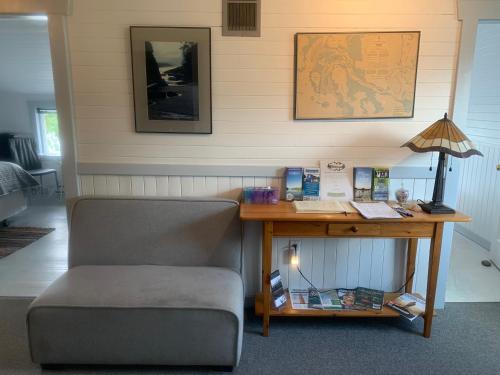 a desk with a chair next to a table with a lamp at Tofino Paddlers Inn in Tofino