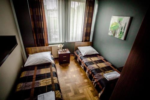 two twin beds in a room with a window at Restauracja Sonata in Zwierzyniec