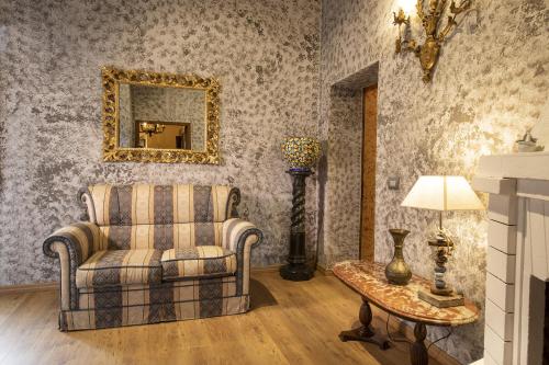 - un salon avec une chaise et une table dans l'établissement La Togata Hotellerie de Charme - Relais il Pozzo, à Montalcino