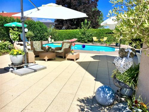 a patio with a pool and chairs and an umbrella at Charming Villa with Private Swimmingpool in Attalens