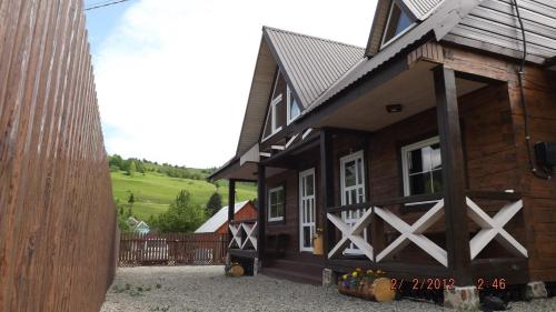 a wooden house with a gate and a fence at "Файна хата" in Synevyrsʼka Polyana