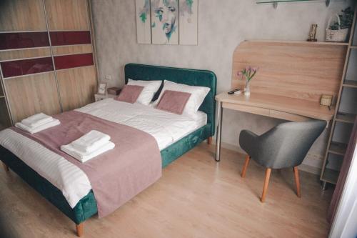 a bedroom with a bed and a desk and a chair at Kiev Home Apartments - станция метро Шулявская и рядом три ТЦ "Мармелад", "Аркадия", "Космополит" in Kyiv